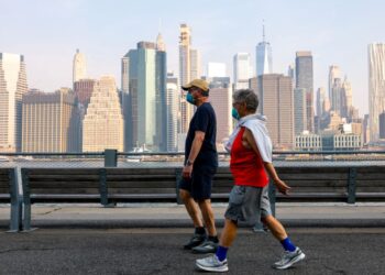 DUA warga emas memakai pelitup muka ketika berjalan di Taman Jambatan Brooklyn, New York.- AFP