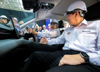 JOHARI (memegang stereng kereta) bersama Sim Tze Tzin pada pelancaran pengeluaran kereta Proton e.MAS 7 PHEV secara pemasangan tempatan (CKD) di Kilang Kenderaan Elektrik (EV) Proton, Tanjung Malim semalam.
