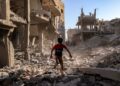 SEORANG budak lelaki berjalan melalui runtuhan bangunan yang musnah akibat pengeboman Israel di kem Maghazi di tengah Gaza.- AFP