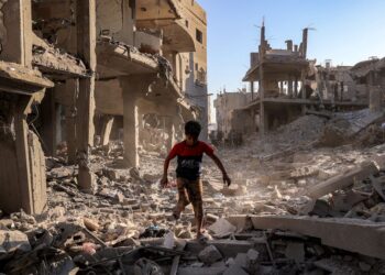 SEORANG budak lelaki berjalan melalui runtuhan bangunan yang musnah akibat pengeboman Israel di kem Maghazi di tengah Gaza.- AFP