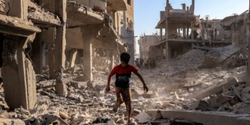 SEORANG budak lelaki berjalan melalui runtuhan bangunan yang musnah akibat pengeboman Israel di kem Maghazi di tengah Gaza.- AFP