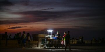 PENJAJA terpaksa menggunakan lampu mudah alih untuk berniaga di Malecon, ekoran gangguan bekalan elektrik di seluruh Cuba Isnin lalu.- AFP