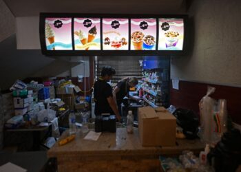 PETUGAS kesihatan menguruskan bekalan ubat di dalam restoran McDonald's yang beroperasi sebagai pusat rawatan perubatan sementara di Caraballeda, La Guaira.- AFP