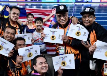 Datuk Abdul Latif Romly meraikan kejayaannya meraih pingat emas dalam acara lompat jauh yang juga merupakan emas kelima kontinjen Malaysia bersama Ketua Pengarah Majlis Sukan Negara (MSN) Jefri Ngadirin di Sukan Komanwel 2026, Glasgow, semalam. - IHSAN MSN