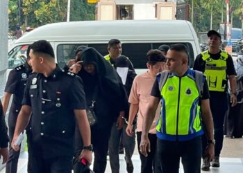 EMPAT individu termasuk anggota tentera wanita diiringi polis ketika tiba di Kompleks Mahkamah Kuala Lumpur bagi pertuduhan menipu seorang lelaki melibatkan pelaburan minyak wangi bernilai RM38,400, di sini hari ini.