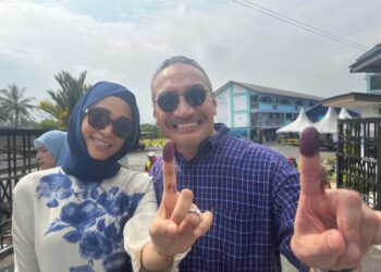 HISHAMMUDDIN bersama isterinya, Datin Seri Marsilla Tengku Abdullah di pusat mengundi di Sekolah Agama Taman Sri Lambak, di sini.