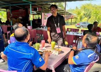 MOHD Aidil Abdullah menyantuni pengundi DUN Juasseh di sebuah kedai makan di Beting, Kuala Pilah, semalam. – UTUSAN/NOR SHAFIQAH MOHD GHAZALI