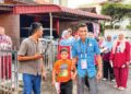 Ahmad Faez Abdul Razak menyantuni orang ramai ketika berkempen dari rumah ke rumah di DUN Labu, Negeri Sembilan. -IHSAN FACEBOOK