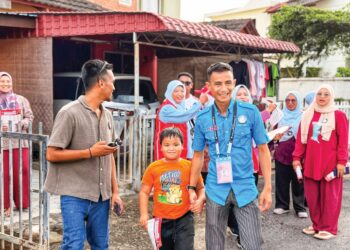 Ahmad Faez Abdul Razak menyantuni orang ramai ketika berkempen dari rumah ke rumah di DUN Labu, Negeri Sembilan. -IHSAN FACEBOOK
