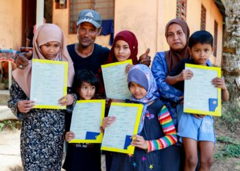 ZAPNI Abd. Wahab (dua kiri) gembira selepas anak-anaknya menerima  sijil kelahiran di Kampung Johal, Kuala Krai, Kelantan semalam. – UTUSAN/KAMARUL BISMI KAMARUZAMAN