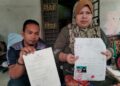 MUHD. Amirul Asyraf Abdul Aziz dan ibunya menunjukkan surat keputusan carian dari daftar daripada Jabatan Pendaftaran Negara untuk proses mendapat hak kerakyatan ketika ditemui di Kampung Apal, Besut, Terengganu semalam. -UTUSAN/WAN ZURATIKAH IFFAH WAN ZULKIFLI