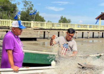 MOHD. Faizal Ramli menyantuni salah seorang nelayan di jeti nelayan Kampung Sungai Sekawang, Linggi, Port Dickson, Negeri Sembilan.