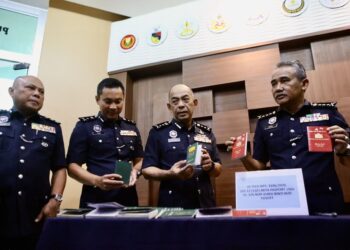 ADZLI Abu Shah (kanan) bersama pegawai kanan polis menunjukkan pasport yang dirampas dalam serbuan terhadap sindiket permit kerja dan kad UNHCR palsu pada sidang akhbar di IPK Kedah, Alor Setar. - UTUSAN/ SHAHIR NOORDIN