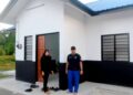 MAZIAH Abd. Malek bersama anak lelakinya, Muhamad Hafiz Jamaludin di hadapan rumah baharu projek Rumah Rakyat Pahang (RRP) di Kampung Bukit Rang, Pulau Tawar, Jerantut, Pahang. - UTUSAN/HARIS FADILAH AHMAD