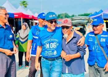 Mustapha Nagoor (kiri) beramah mesra dengan para penduduk di sekitar kawasan Pasar Tani Keluarga Malaysia, Palong, Jempol semalam.