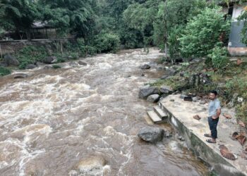 KAMAL Rizal Mat Isa menunjukkan keadaan Sungai Sedim di Kulim yang masih berarus deras selepas dilanda kepala air kelmarin.