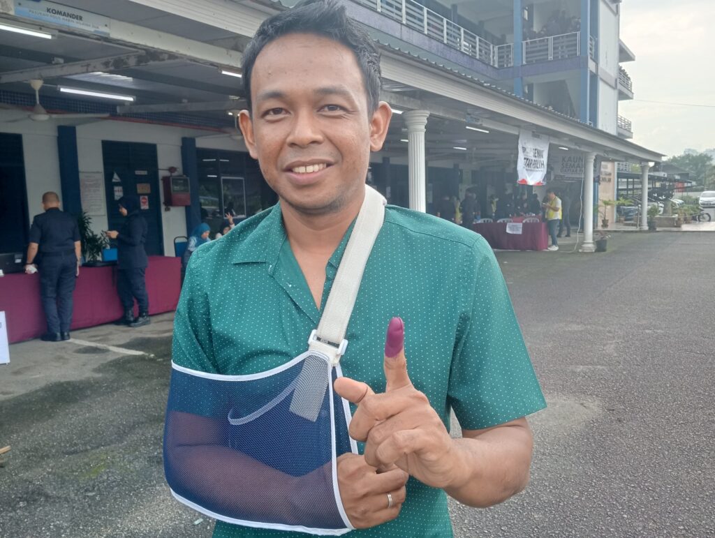 Broken arm doesn't stop Corporal Mohd. Ilham from voting