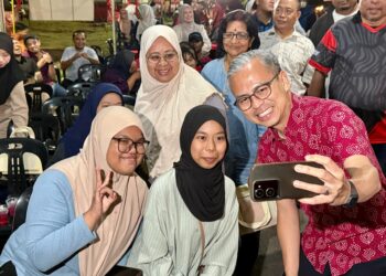 FAHMI Fadzil bergambar bersama penduduk ketika menghadiri Program Wayang Pacak di Pekan Rompin, Jempol, malam ini.- UTUSAN/NOR SHAFIQAH MOHD. GHAZALI