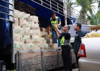 HANIF Yusabra Yusuf (tengah) memeriksa minyak masak peket yang berjaya dirampas dalam serbuan di Kampung Pauh Sembilan, Bachok, Kelantan hari ini-UTUSAN/KAMARUL BISMI KAMARUZAMAN.