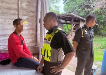 SUSPEK (kiri) semasa ditahan selepas cuba menyeludup minyak masak paket dalam serbuan di Kampung Pauh Sembilan, Bachok, Kelantan hari ini.