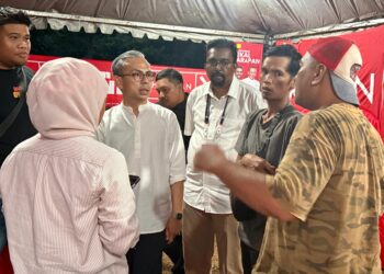 FAHMI Fadzil  menyantuni pengundi Dewan Undangan Negeri (DUN) Jeram Padang bersama calon PH , G. Manivanan di Felda Bukit Rokan Barat, Jempol, hari ini.- UTUSAN / NOR SHAFIQAH MOHD GHAZALI