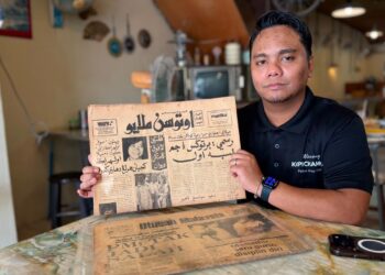 MUHAMMAD Faiz Hilmy menunjukkan naskhah Utusan Melayu bertulisan Jawi dan Utusan Malaysia berusia hampir lima dekad di Gurun, Kedah. – UTUSAN/JAMLIAH ABDULLAH