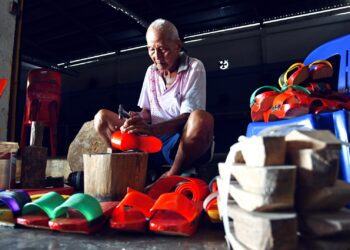 CHOO Kong Choon tekun menyiapkan tempahan terompah kayu tradisional di Dewan Tokong Tau Boo Keong, Bukit Lagi, Kangar, Perlis. – UTUSAN/IZLIZAN OTHMAN