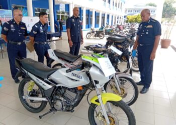 HANYAN Ramlan (kanan) melihat sebahagian motosikal curi yang berjaya ditemukan semula setelah menahan tujuh suspek termasuk tiga beradik yang masih bersekolah pada sidang akhbar di IPD Kuala Muda, Sungai Petani.