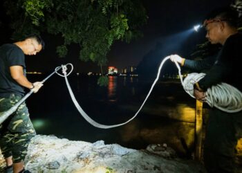 ANGGOTA Perhilitan cuba memasang jerat di Pantai Tanjung Gemok, Port Dickson semalam iaitu lokasi video tular di media sosial yang memaparkan seekor buaya yang naik ke kawasan pantai semalam.-UTUSAN/MOHD. SHAHJEHAN MAAMIN.