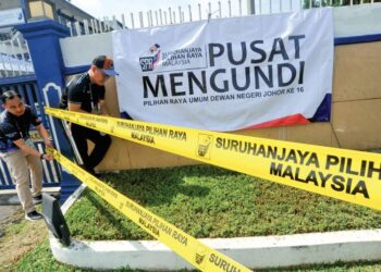PETUGAS Suruhanjaya Pilihanraya (SPR), Ahmad Radzi Mohamed (kiri) dan Khairul Azam Mohd. Hamdan memasang tali penghadang dan banting sebagai persiapan pengundian awal hari ini di pusat pengundi di Markas Pasukan Polis Marin Wilayah 2, Kampung Pengkalan Tinting, Johor Bahru, semalam. - UTUSAN/RAJA JAAFAR ALI