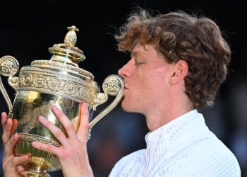 Jannik Sinner mencium trofi selepas menjuarai Kejohanan Wimbledon selepas menewaskan Alexander Zverev dalam perlawanan akhir di London, semalam. - AFP