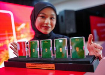 KAKITANGAN Pos Malaysia menunjukkan sebahagian daripada produk emas terpilih, termasuk jongkong emas edisi khas seberat satu gram 'Pos World'  sempena pelancaran Pos ArRahnu Gold-i di Ibu Pejabat Pos Malaysia Kompleks Daya Bumi di sini hari ini. - UTUSAN/SADDAM YUSOFF.