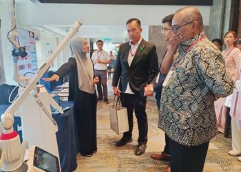 PESERTA Persidangan Kanser Kulit Sabah 2026 menyaksikan pameran sempena persidangan itu. - UTUSAN/HARDY JOE