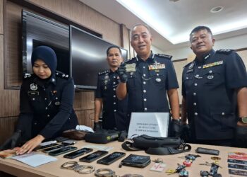 MOHD. Alwi Zainal Abidin menunjukkan kad kuasa polis yang dirampas daripada seorang daripada tiga suspek menyamar polis di kawasan Pantai Remis, minggu lalu.