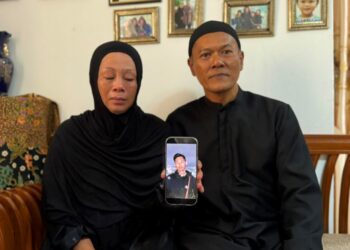 ZULFAH Fadliani (kiri) dan suaminya, Ahmad Ros Abidin menunjukkan gambar Ahmad Shah di kediaman mereka di Bandar Tasik Puteri, Rawang, Gombak, semalam.