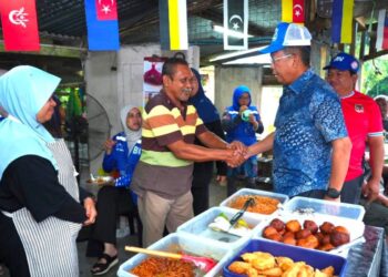 JALALUDDIN Alias (kanan) bersalaman dengan peniaga di kedai Mak Tam Jah Kampung Lakai, Jelebu semalam.
