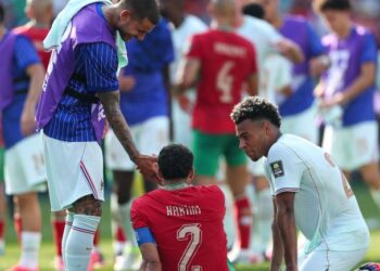 Pemain Perancis, Lucas Hernandez dan Desire Doue cuba menenangkan tonggak Maghribi, Achraf Hakimi (tengah) selepas perlawanan suku akhir di Stadium Boston, Foxborough, Massachusetts, semalam. - AFP