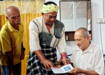 BADRUL Hisham Alias (tengah) menyampaikan Mykad kepada seorang penerima warga emas sempena program Literasi Pendaftaran melalui MEKAR Komuniti di Kampung Kedondong Pulau Tawar di Jerantut, Pahang.
