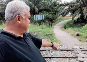 MOHD. Safri Salleh menunjukkan landasan kereta api yang digunakan penduduk untuk menyeberang di Kampung Mela, Lipis, Pahang.