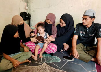 Nur Syafiqah Mohd. Khair (dua dari kanan) bersama adik-beradiknya memikul tanggungjawab menjaga Muhammad Harith Syauqi yang menghidap sindrom Down serta autisme di Felda Lurah Bilut, Bentong, Pahang.
