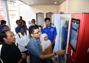 AKMAL Nasrullah Mohd Nasir membuat pembelian di mesin Inisiatif Pendapatan Rakyat (IPR) yang ditemptatkan di lokasi strategik di kampus Alam Unimap, Pauh Putra, Perlis semalam.-UTUSAN/IZLIZAN OTHMAN