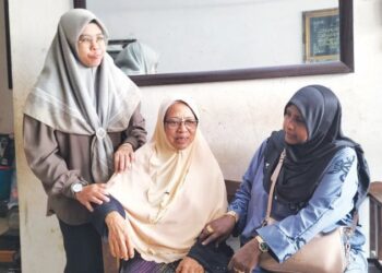 SALMAH Samsudin (tengah) ketika menerima kunjungan jiran-jiran selepas mereka mengetahui tragedi yang menimpa anak lelaki tunggalnya itu di rumahnya di Bukit Gedung, Pulau Pinang.-UTUSAN/SAFINA RAMLI