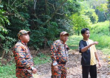 MUHAMMAD Ali Imran Shahir (kanan) ketika turut-serta dalam operasi SAR untuk mengesan bapanya di Dusun Durian Pusat Pertanian Relau, Pulau Pinang hari ini.-UTUSAN/DANIAL SAAD