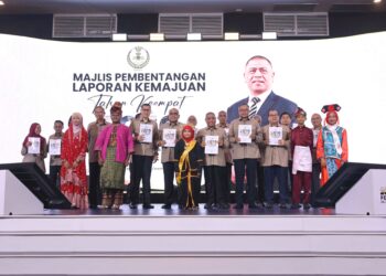 SAARANI Mohamad (tengah) menunjukkan buku Laporan Kemajuan Tahun Keempat Perak Sejahtera 2030 ketika pembentangan di Ipoh, Perak semalam.