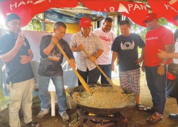 ZUHAN Zain (tiga dari kiri) bersama jentera PH menggodak bubur asyura sebelum diedarkan kepada orang ramai di sekitar Taman Ilham dan Taman Indah Jaya di Kluang.