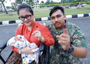 KOPERAL Mohammad Nazrin Saharudin 34, dan Isteri, Nur Asyikin Maznan 31, yang baru lima hari melahirkan anaknya, menunjukkan jari selepas selesai membuang undi sempena Pilihan Raya Negeri (PRN) Johor ke-16 di Kem Mahkota, Kluang, di sini hari ini. UTUSAN/SHIDDIEQIIN ZON