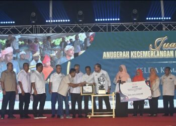 ANWAR Ibrahim bersalaman dengan Muhammad Azmi Jali yang menerima hadiah Anugerah Kecemerlangan Felda (AKRF) 2026 dimenangi Felda Kemahang 3, Tanah Merah Kelantan pada Sambutan Hari Peneroka 2026 dan 70 Tahun Felda di Stadium Tun Abdul Razak (STAR) Jengka di Maran, Pahang. - FOTO/SHAIKH AHMAD RAZIF