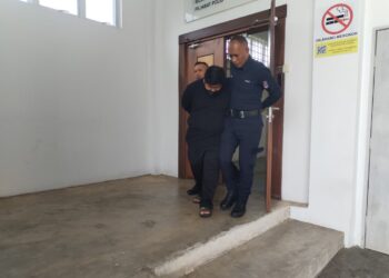 MUHAMMAD Izzuddin Mohmad Asari (tengah) dibawa keluar dari Mahkamah Seksyen Besut, Terengganu. -  UTUSAN /WAN ZURATIKAH IFFAH WAN ZULKIFLI