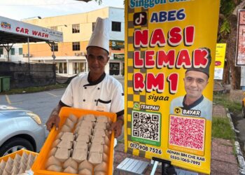ADNAN Che Kar menunjukkan nasi lemak RM1 dijual di Kota Bharu, Kelantan. – UTUSAN/ ROSLIZA MOHAMED