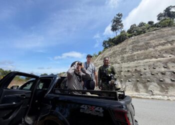 ROSLAN Abu Kassim (kanan) bersama dua pelancong 'Mat Saleh' menyertai aktiviti memerhati burung liar di Lembah Enggang Tembeling berdekatan Kuala Tahan di Jerantut, Pahang. - UTUSAN/HARIS FADILAH AHMAD